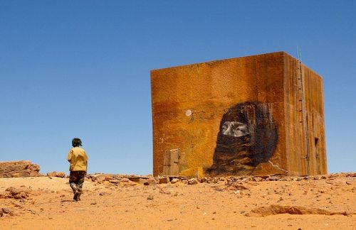Un bloque de marmol en el desierto en el que está pintado el rostro de un saharaui