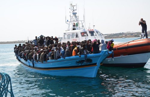 Policía de Frontex vigilan una embarcación llena de inmigrntes