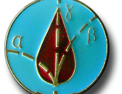 Medalla metálica con esmalte azul, en el centro una gota de sangre roja atravesada por unas líneas