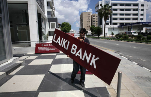 Un obrero lleva un cártel con el nombre de un banco