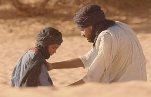 Un hombre habla con un niño en el desierto