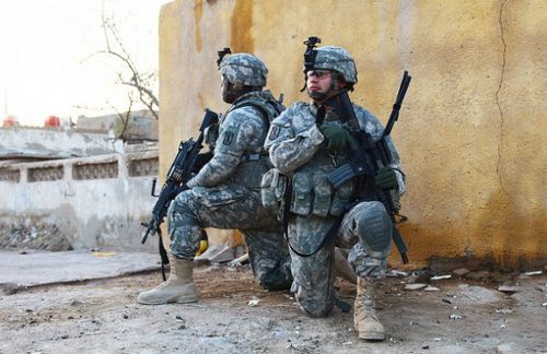 Dos soldados americanos armados arrodillados espalda contra espalda