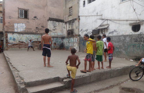 Unos adolescentes juegan al fútbol en las ruinas de una casa