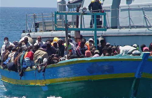 Un barco italiano remolca otro de inmigrantes