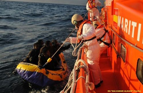 Una lancha española de salvamento acerca la embarcación hinchable en la que van inmigrantes 