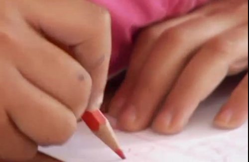 las manos de una niña dibujando