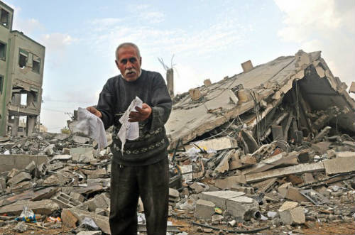 Palestino ante ruinas casa