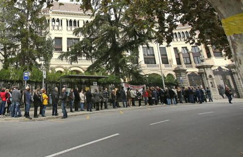 Larga fila de personas en la calle esperando turno para votar