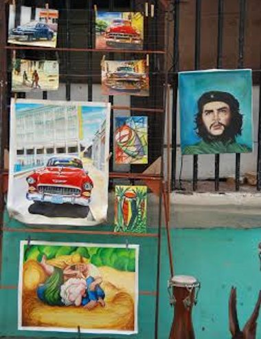 Fotografías de coches, cuadros y del Che Guevara sujetos con alfileres de la ropa en la verja de una ventana