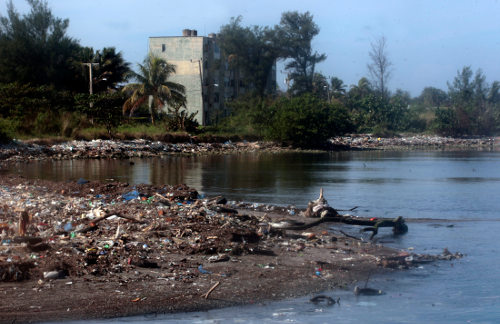 Gran cantidad de basura tirada junto a la orilla del río