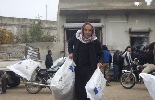 Un hombre lleva dos sacos de ayuda humanitaria de la UE