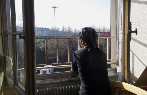 Una mujer joven mira por la ventana