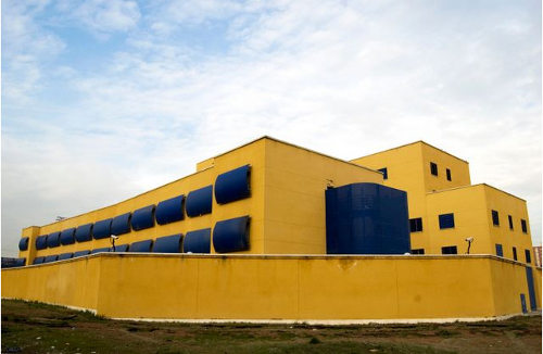 Un edificio amarillo con persianas que ciegan las ventanas