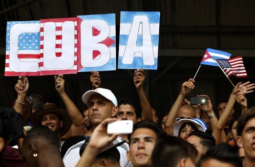 Personas con banderas de Estados Unidos y Cuba en las gradas