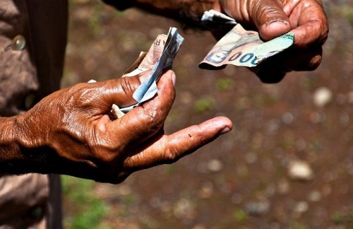 Las manos de una persona anciana cuenta billetes