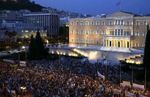 La Plaza Sintagma reprleta de ciudadanos, el parlamento griego iluminado al fondo