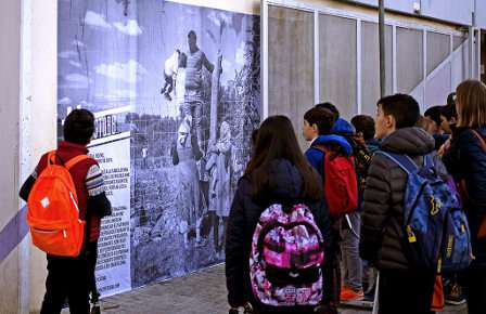 Unos estudiantes miran el cartel del PE del Día de la mujer trabajadora