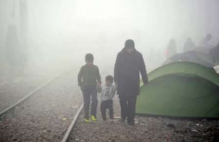 Una mujer y sus dos hijos caminan entre la niebla